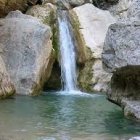 Tranquil waterfall painting with rowboat scene