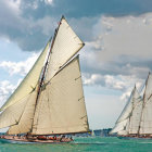 Majestic tall ships with white sails on choppy blue ocean