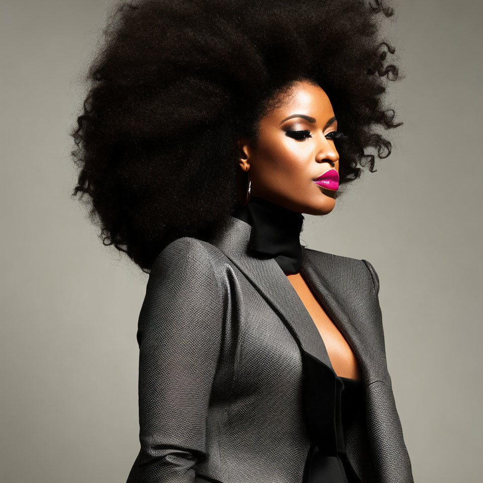 Stylish woman with curly hair in gray blazer and bold lipstick