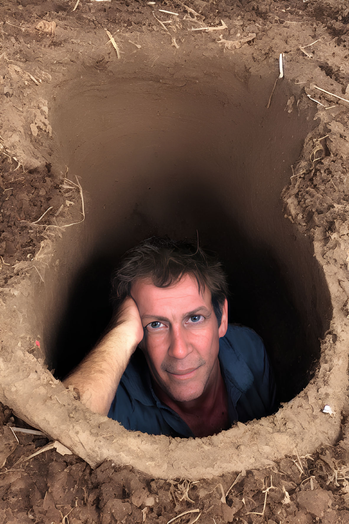 Man peeking from deep circular dirt hole with intrigued expression