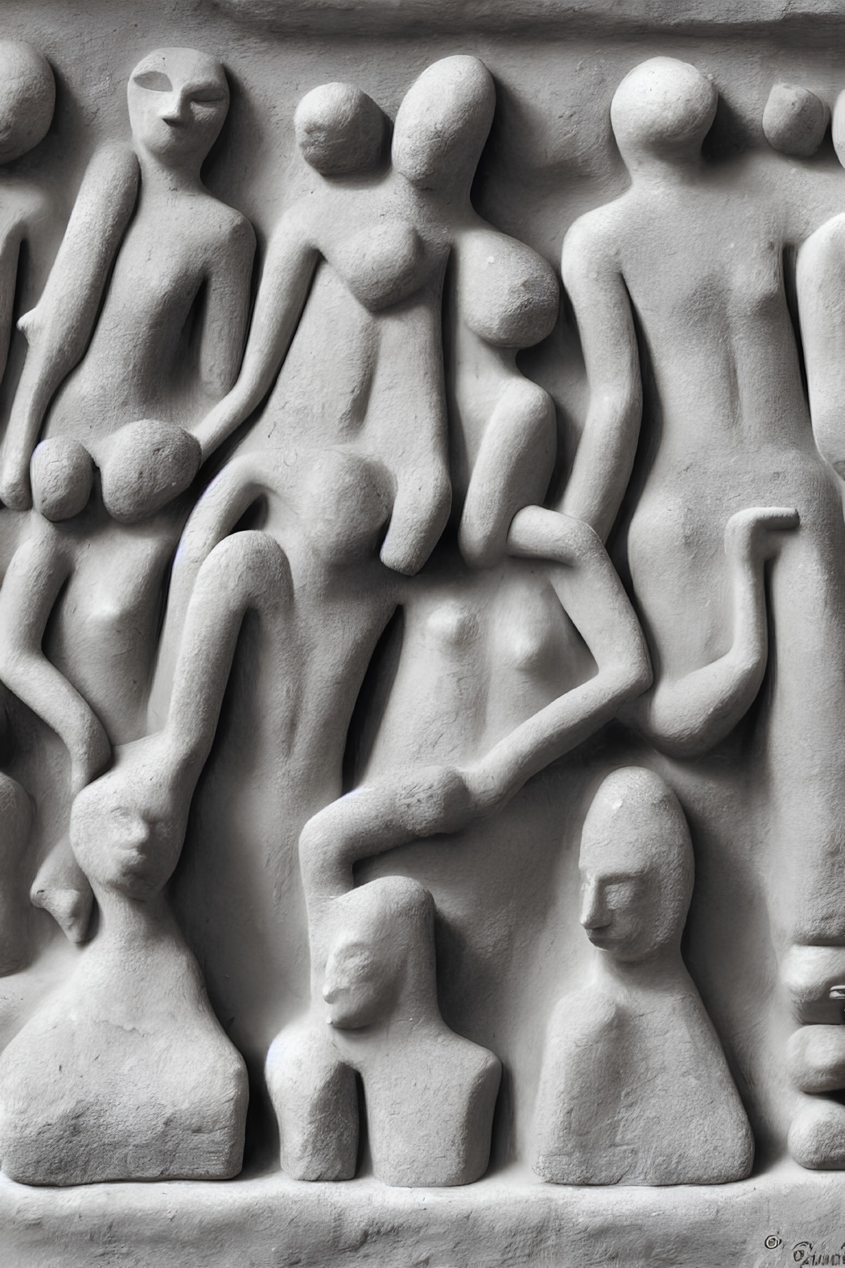 Monochromatic close-up photo of abstract human figures in stone relief