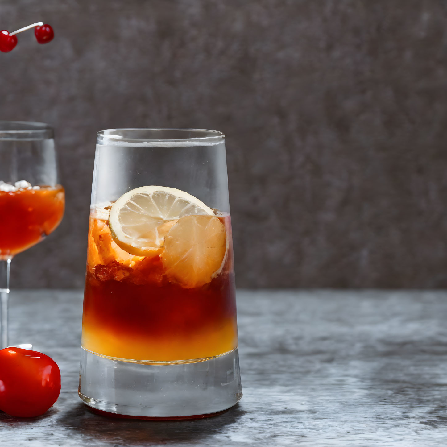 Layered Amber Cocktail with Lemon Slice and Ice in Tall Glass