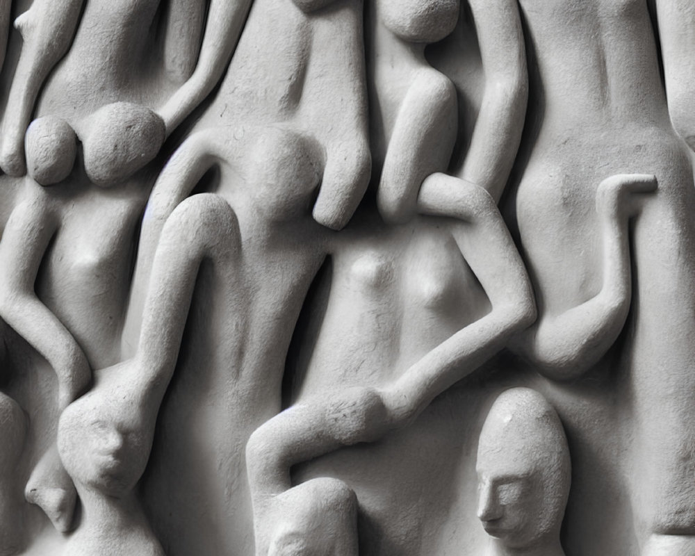 Monochromatic close-up photo of abstract human figures in stone relief