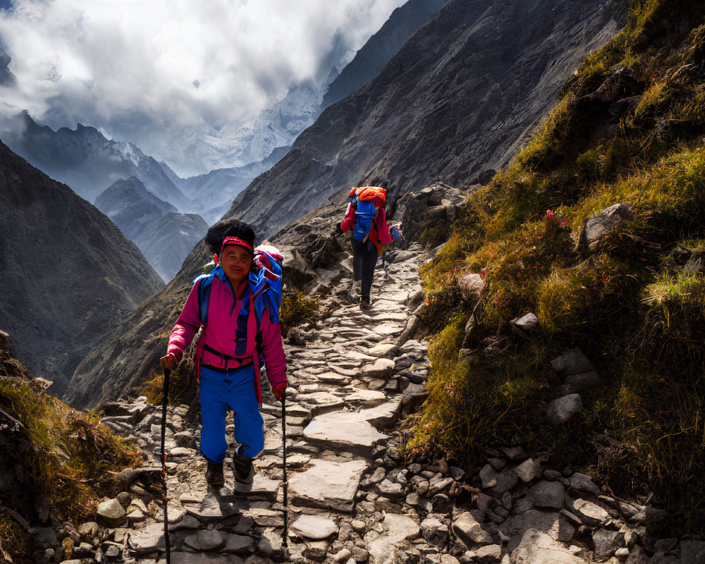 Hikers trekking on rocky mountain path with lush greenery and misty peaks