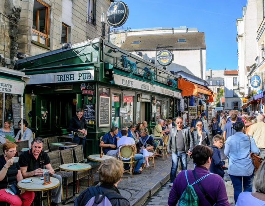 Urban Irish pub street scene with people dining and walking on a sunny day