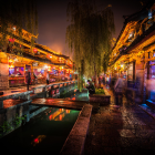 Nighttime Asian Garden with Illuminated Classical Buildings and Tranquil Pond