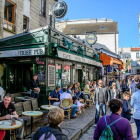 Urban Irish pub street scene with people dining and walking on a sunny day