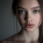 Woman's face with water droplets, misty background, soft focus