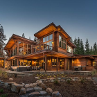 Rustic log cabin with lit windows amidst colorful tulips