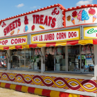 Vibrant outdoor market with fruit stands and food kiosks under blue sky