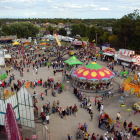 Colorful Medieval Fair with Tents, Crowds, Flags, and Cloudy Sky