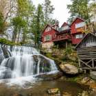 Tranquil waterfall under bridge in misty forest village