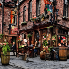 Cobblestone street with old-fashioned pub and vibrant flower displays