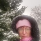 Person with blue eyes in winter scene with snowflakes and pine branches