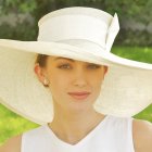 Portrait of woman with pale skin and red cheeks in white laced hat against starry backdrop