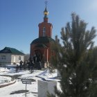 Golden spire church in snowy landscape under blue sky