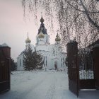 Snow-covered Orthodox church in serene winter scene under twilight sky