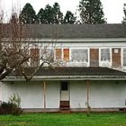 White Two-Story House with Wraparound Porch and Green Shutters