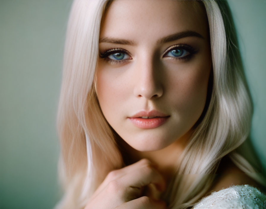 Blonde Woman Portrait with Blue Eyes and Fair Skin on Muted Green Background