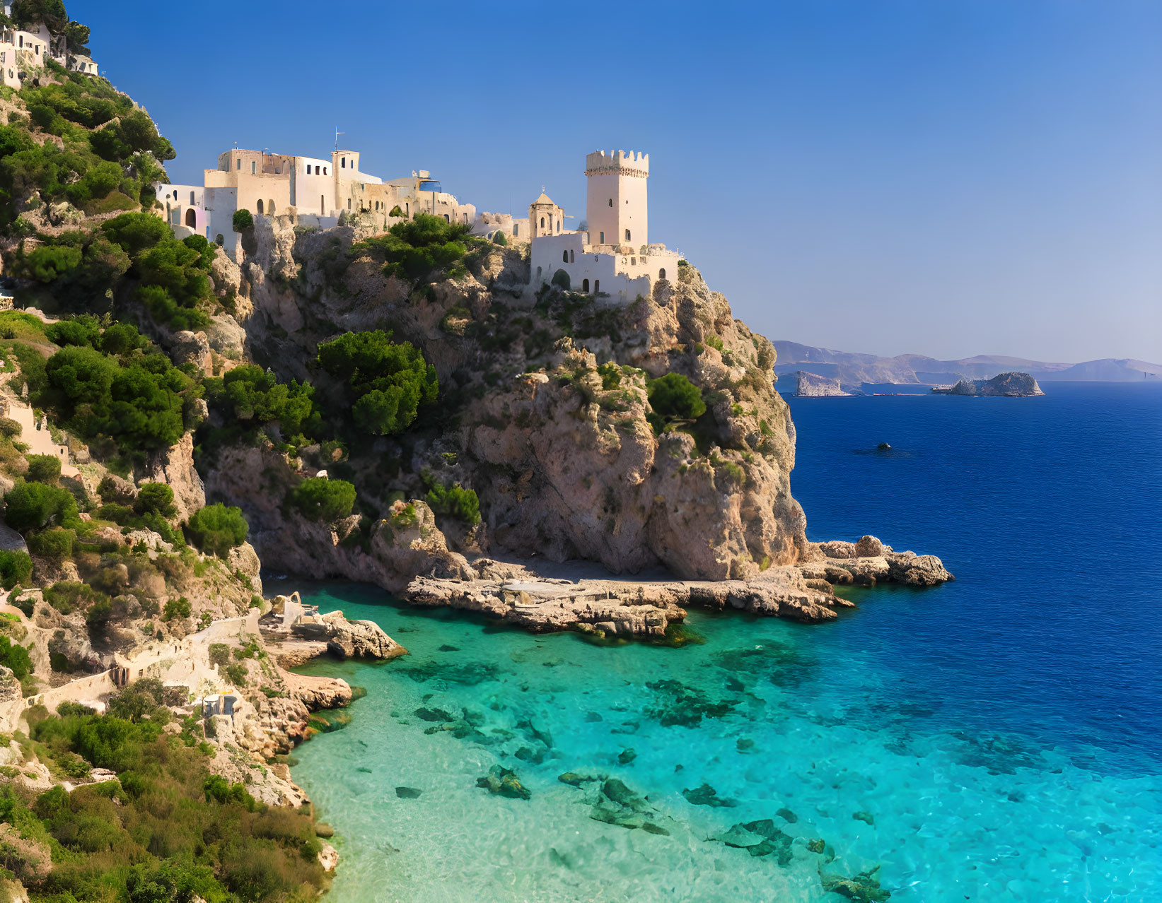 Clifftop castle overlooking tranquil sea and rocky shoreline