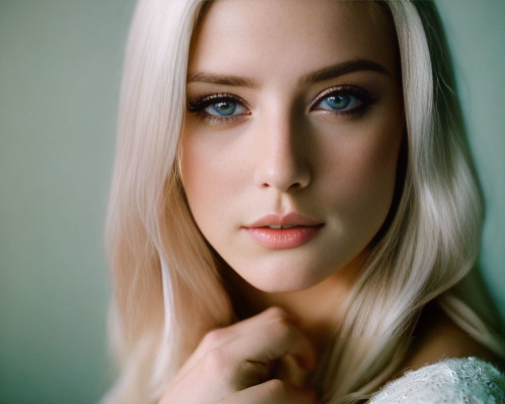 Blonde Woman Portrait with Blue Eyes and Fair Skin on Muted Green Background