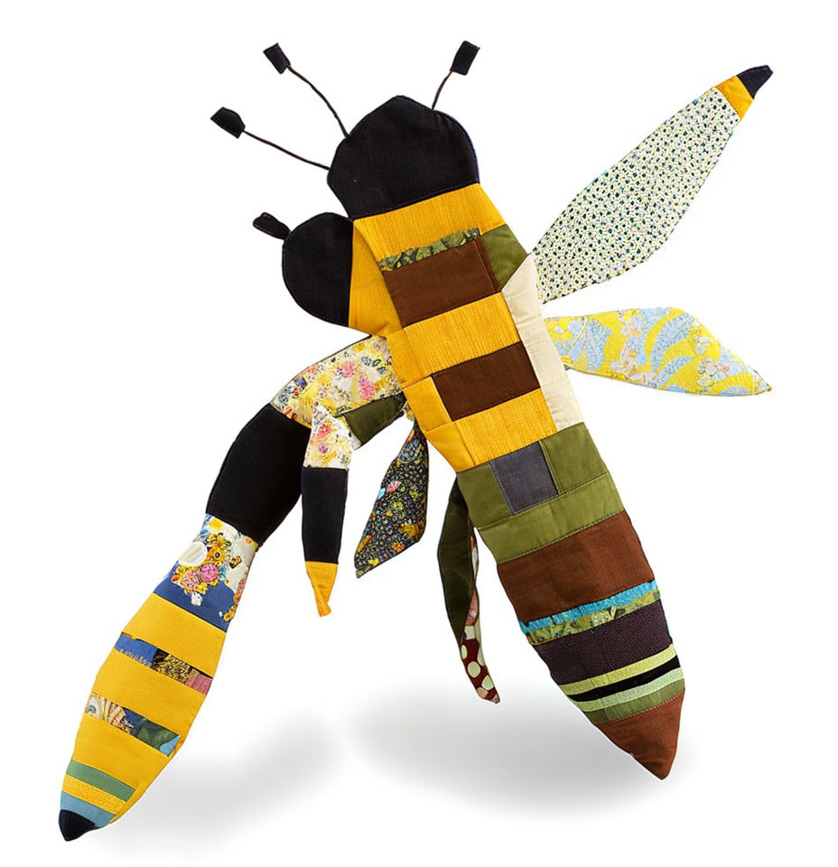 Colorful patchwork fabric bee with various patterns on wings and body on white background