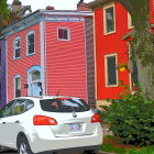 Vibrant residential street with colorful houses and parked car
