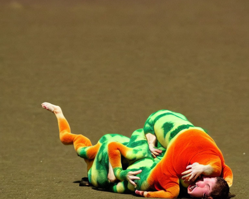 Person in orange shirt and green pants posing dramatically on the ground