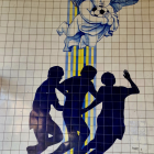 Dynamic mural featuring boy in hat with shadowed children playing on geometric background