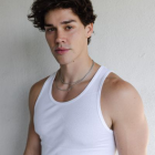 Curly-haired man in white tank top with geometric shadows