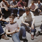 Vintage Attire Group Sitting on Steps with Central Figure Cleaning Shoes