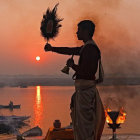 Woman in elegant attire holding feathered plume by water at sunset with child.