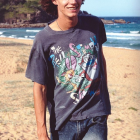 Person with colorful dot patterns on beach cliffs.