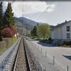 Serene village scene with rustic railway track and vintage cart