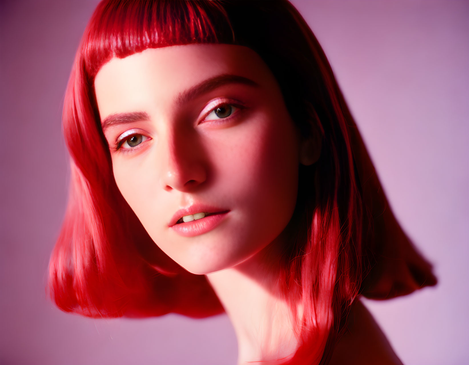 Person with Vibrant Red Bob Haircut and Fair Skin on Pink Backdrop