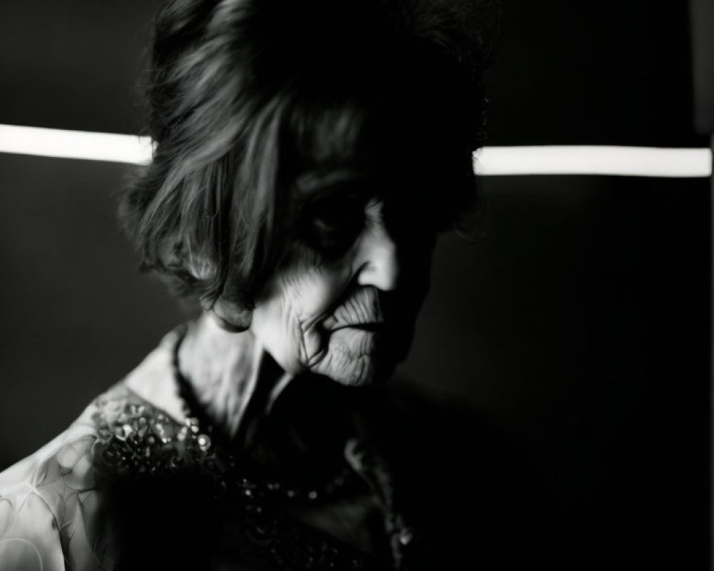 Elderly woman with dark hair in decorated attire on dark background