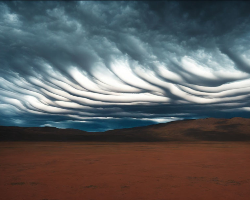 Dramatic landscape with wave-like clouds over barren desert plain