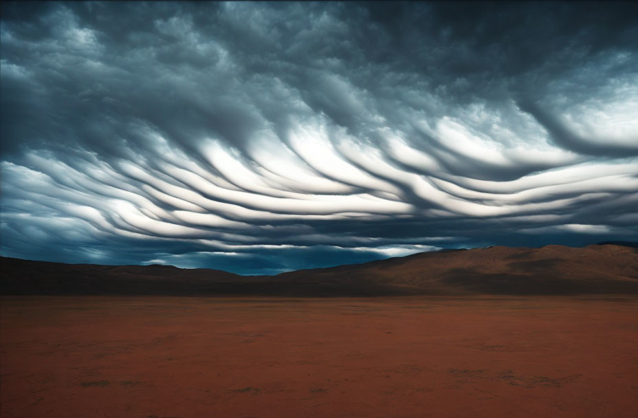 Dramatic landscape with wave-like clouds over barren desert plain