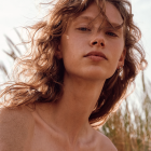 Young woman's digital portrait with flowing hair and flowers in soft light.