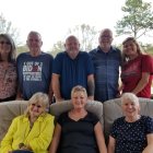 Formal multi-generational family portrait on luxurious outdoor sofa