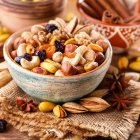 Assorted fruits and berries with edible flowers and nuts on wooden surface