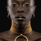 Portrait of woman with striking eyes, dark skin, gold jewelry, and African braided hairstyle