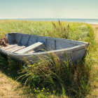 Weathered wooden boat on sandy beach near calm sea