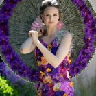 Elaborate peacock-themed attire on woman with peacock beside her