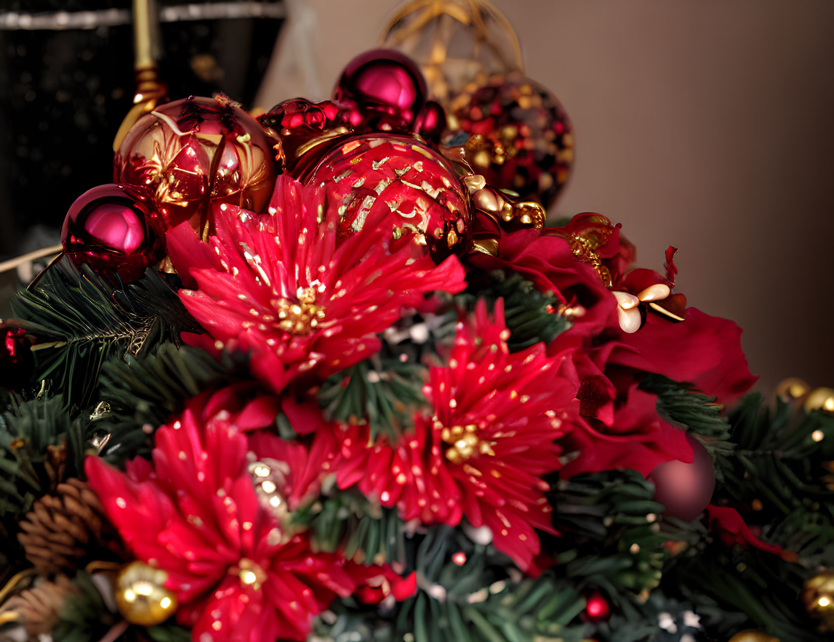 Festive holiday wreath with red poinsettias, gold and red baubles,