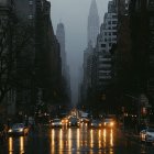 Futuristic cityscape with mist and towering structures lit by warm orange lights