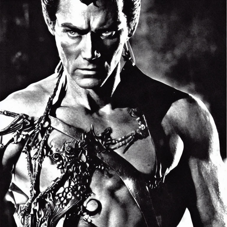 Monochrome image of muscular person in chains and dark costume