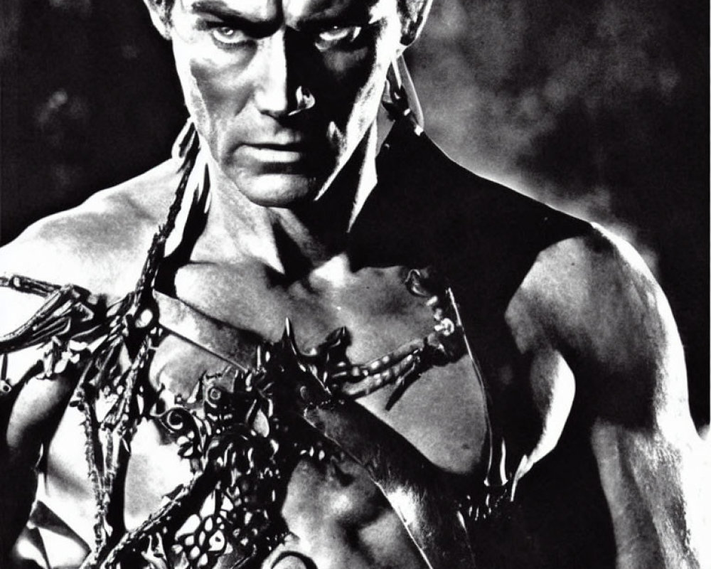 Monochrome image of muscular person in chains and dark costume