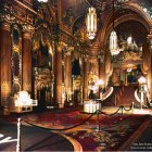 Opulent golden-lit interior with red velvet stairs and grand columns