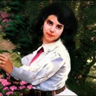 Portrait of woman with dark hair, red lipstick, white shirt, red tie, surrounded by pink flowers